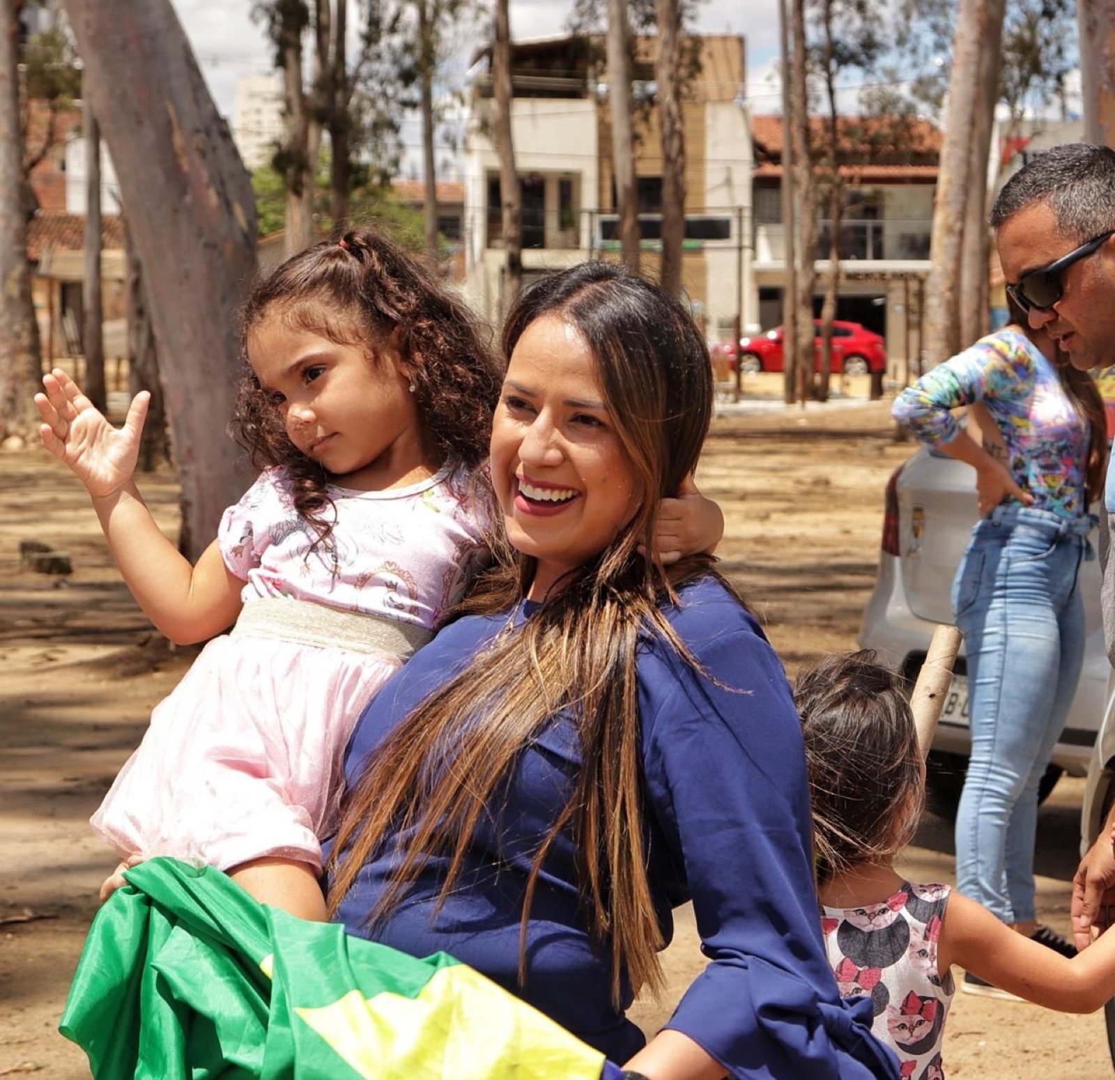 Talita Oliveira com crianças no colo, durante atividade de rua