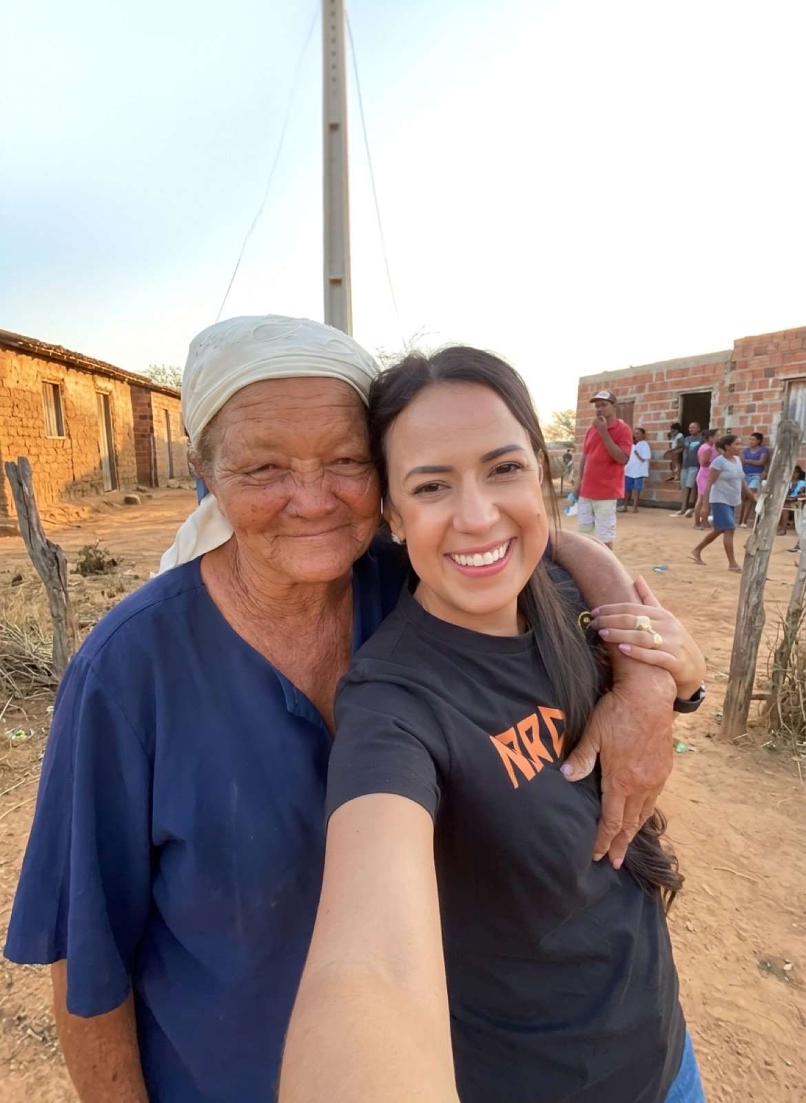 Talita Oliveira abraçada a uma moradora, em comunidade do interior da Bahia
